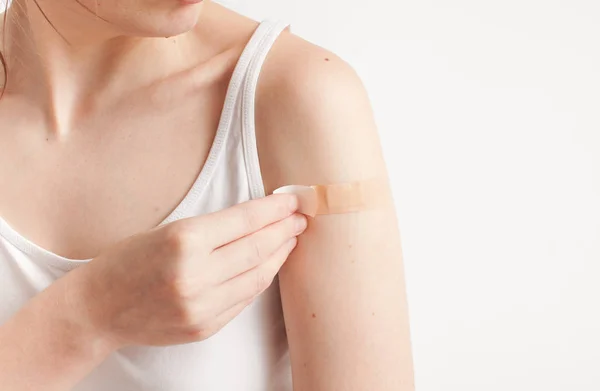 Sticking plaster on hand on white background — Stock Photo, Image