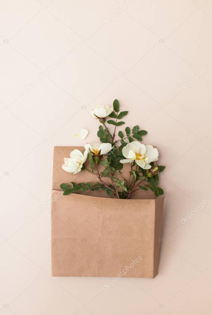 Sprigs of tea light rose in a paper bag