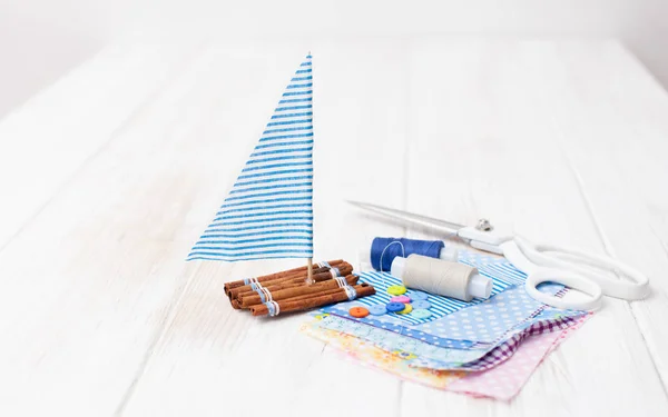 Schip speelgoed en stukken doek met naaien accessoires — Stockfoto