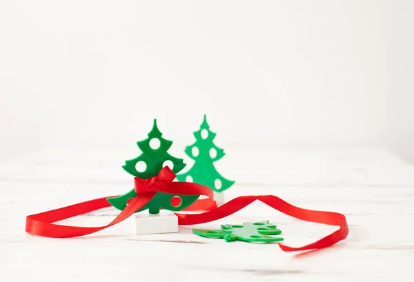 Small green Christmas tree with red ribbon on white — Stock Photo, Image