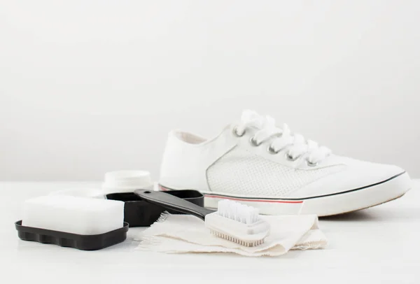 Escova, esponja e creme para sapatos brancos — Fotografia de Stock