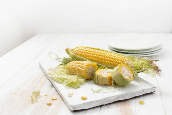 Raw corn on the cob on a white table — Stock Photo, Image