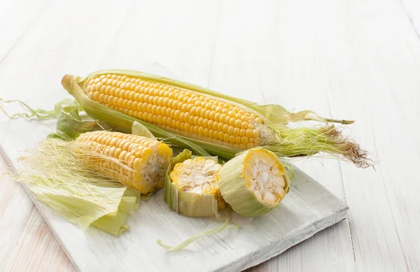 Raw corn on the cob on a white table — Stock Photo, Image
