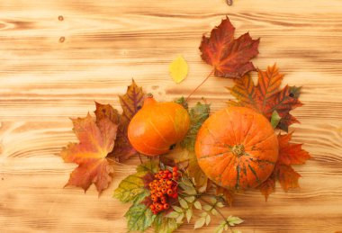 Kabak, sonbahar yaprakları, üvez meyveleri ahşap bir masa üzerinde