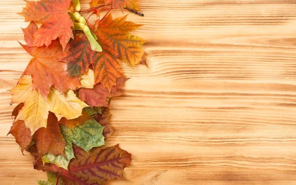 Pruh podzimní listí na dřevěný stůl — Stock fotografie