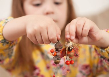 Kız bebek doğal malzemelerden elinde tutan