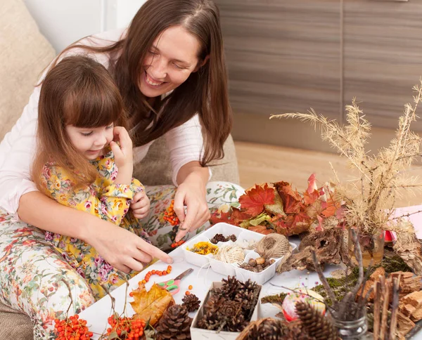 Mother and daughter make dolls from natural materials — Stock Photo, Image