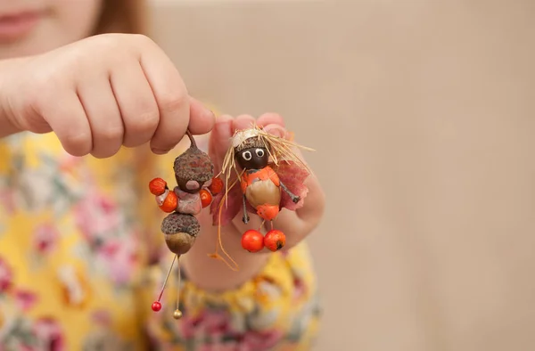 Girl shows dolls from natural materials — Stock Photo, Image