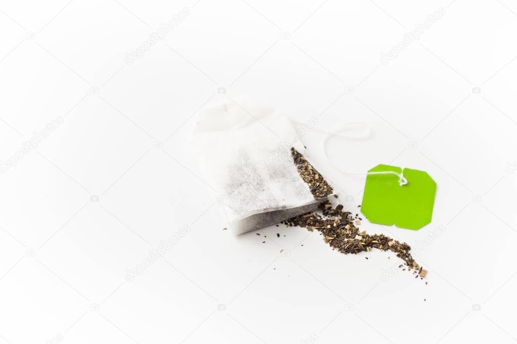 Scattered herbal green tea bag on white background
