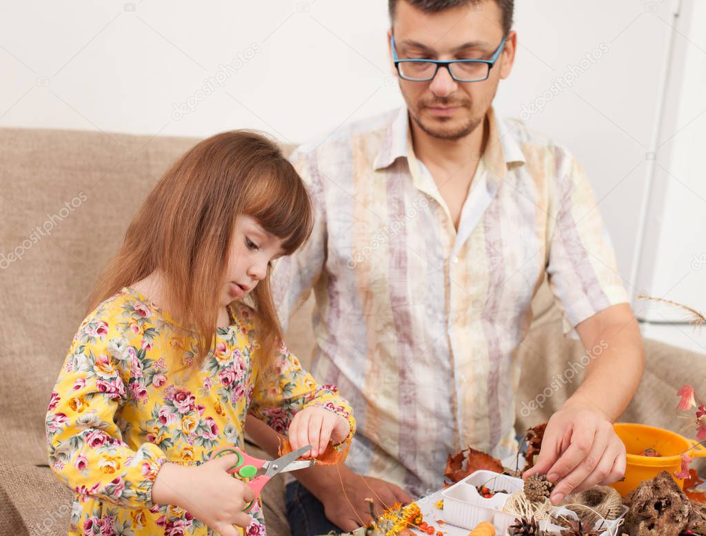 Dad and daughter doing crafts from natural materials