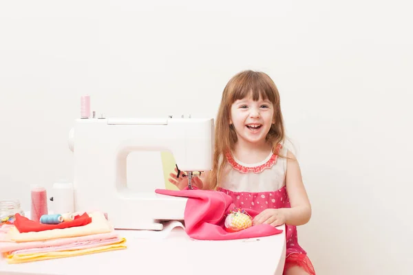 Het meisje houdt zich bezig met naaien naaimachine gebruiken — Stockfoto