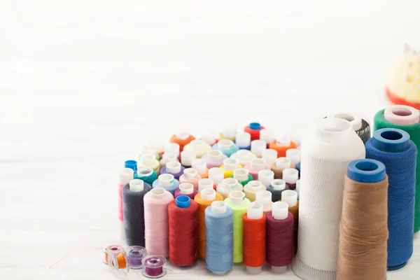 A bunch of colorful sewing threads on white table — Stock Photo, Image