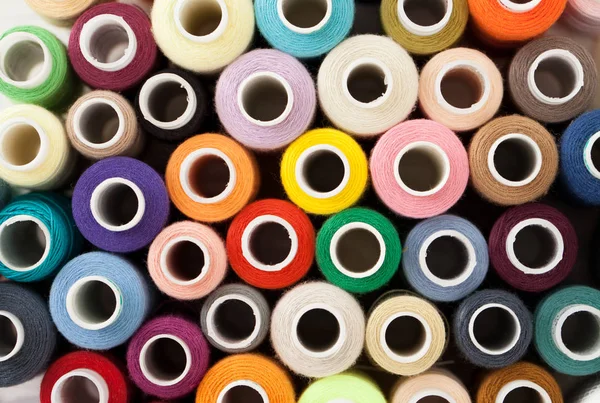 Background of colorful sewing threads on white table — Stock Photo, Image