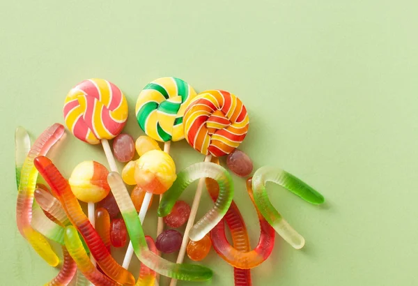 Cadılar bayramında yeşil bir arka plan üzerinde renkli şekerler