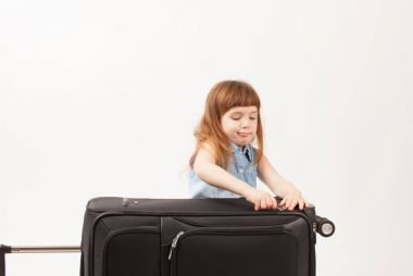 Kız beyaz zemin üzerine bavul kapatır