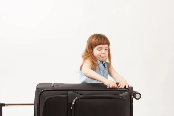 Το κορίτσι κλείνει βαλίτσα σε λευκό φόντο — Φωτογραφία Αρχείου