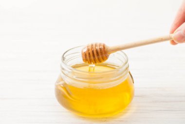 Tahta kaşık bal beyaz el için