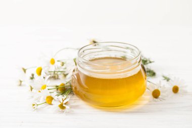 Papatya çiçeği beyaz bir tabloda bir kavanoza tatlım