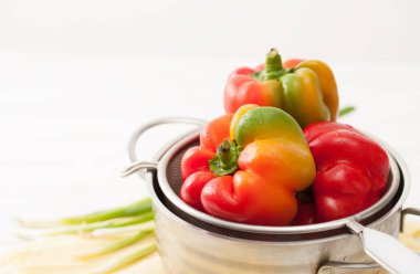 Çiğ renkli tatlı biber, yıkanmış bir elek