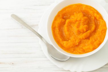 Kabak püresi bir kaseye Kaşık beyaz bir tablo ile