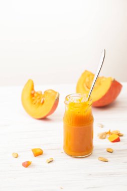 Bir kavanoz ve bir beyaz masaya doğranmış kabak kabak püresi