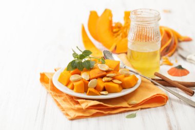 Balkabağı beyaz masaya bal ve tarçın ile parçalar halinde kesilmiş