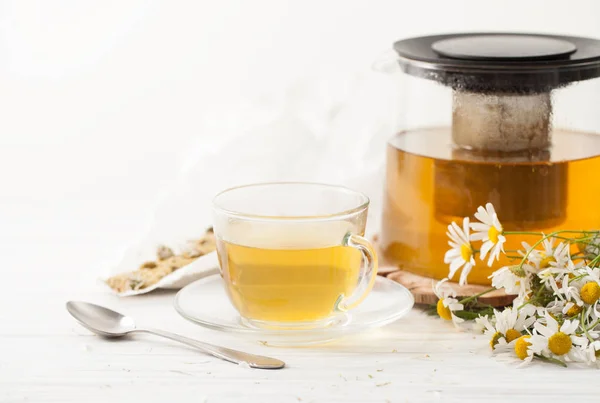 Отвар ромашковых цветов в чашке чая на столе — стоковое фото