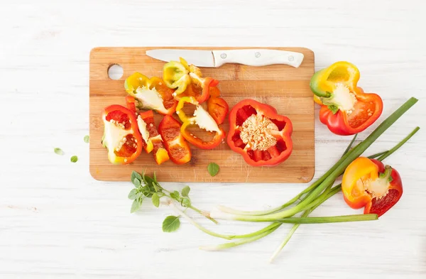 Gehakte kleurrijke paprika en groene uien op wit — Stockfoto