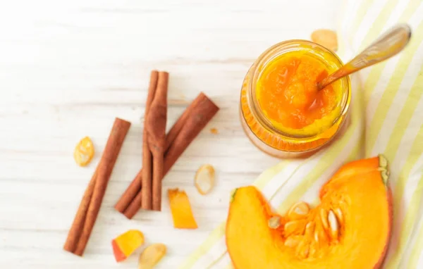 Puré de calabaza en un frasco con canela sobre una mesa blanca — Foto de Stock