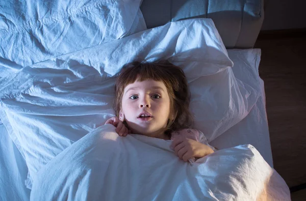 A girl of 4 years is afraid of lying in bed — Stock Photo, Image