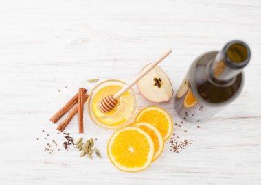 Bir şişe şarap, orange, bal, tarçın beyaz üzerinde mulled şarap için dilimleri
