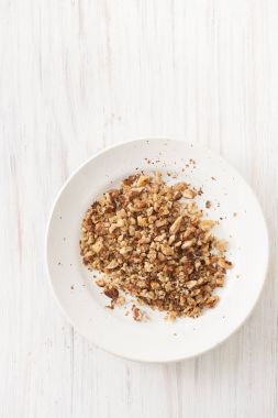 Kıyılmış ceviz beyaz bir tabak içinde kızartma