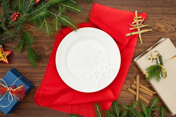 Kerstboom takken en plaat op een rode servet — Stockfoto
