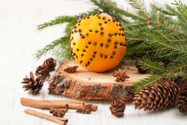 Orange décoré de bâtonnets de clous de girofle cannelle et branche de sapin — Photo