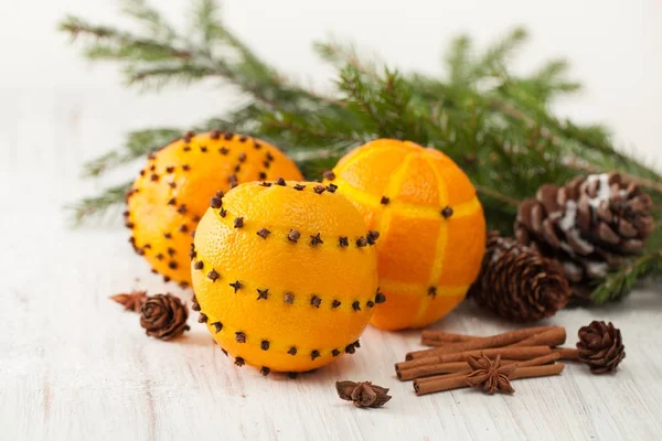 Arance decorate con chiodi di garofano e bastoncini di cannella con pigne — Foto Stock