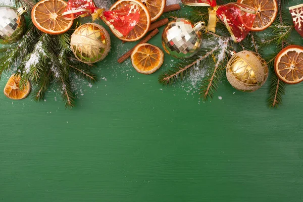 Ramos de abeto nevado com brinquedos de Natal em verde — Fotografia de Stock