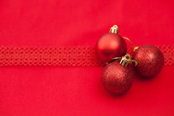 Palle di Natale a maglia rossa con nastro su un tessuto rosso — Foto Stock