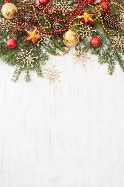 Spruce branches with Christmas ornaments on white wooden background — Stock Photo, Image