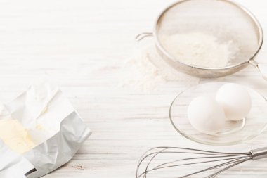 Yumurta, un, tereyağı beyaz bir tablo. Metin için yer.