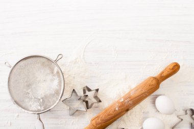 Çerez kesici, yumurta ve un beyaz masaya döküldü. Kopya alanı ile göster