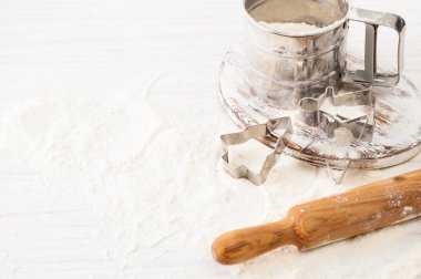 Çerez kesici, elek ve un beyaz masaya döküldü. Kopya alanı ile göster