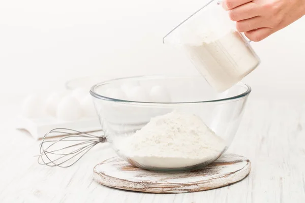 Farinha em uma xícara em uma mesa branca na cozinha — Fotografia de Stock