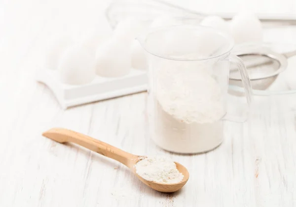 Mehl in einem Holzlöffel auf einem weißen Tisch in der Küche — Stockfoto