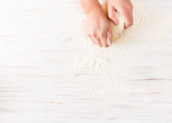 Kneading dough on a white table. View with copy space — Stock Photo, Image