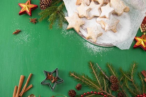 Soubory cookie, posypané moučkovým cukrem s vánoční ozdoby v zelené — Stock fotografie