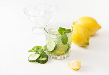 Bardak doğranmış salatalık, nane ve limon beyaz arka plan üzerinde