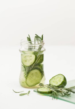 Bardak doğranmış salatalık ve beyaz zemin üzerine biberiye