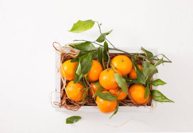 Beyaz arka plan üzerine bir kutu içinde taze mandalina