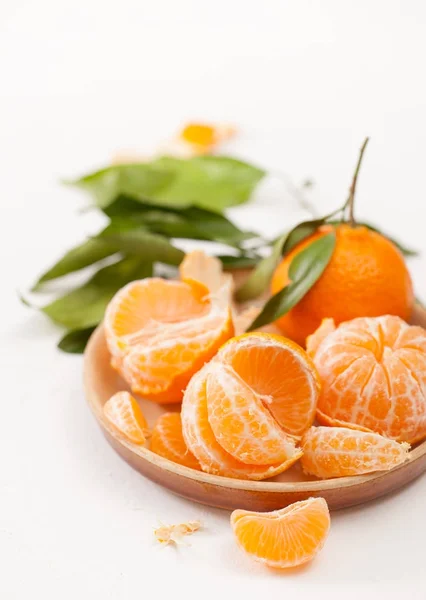 Mandarini pelati e buccia con foglie su sfondo bianco — Foto Stock