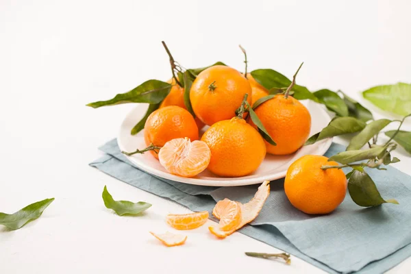 Mandarinas peladas y cáscara con hojas sobre fondo blanco — Foto de Stock